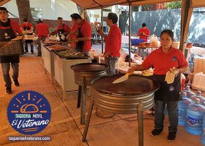 Cocina al aire libre con taqueros.
